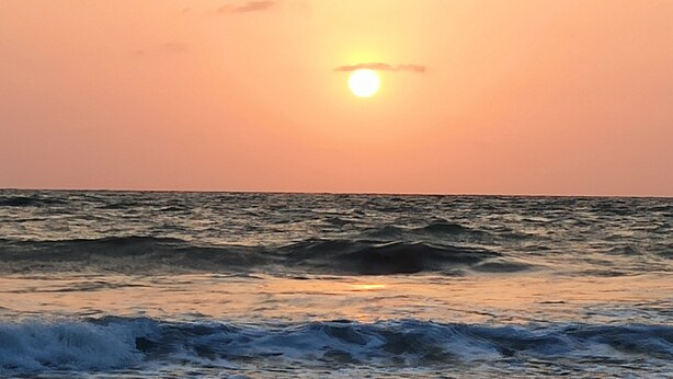 Un atardecer sobre el océano con olas.