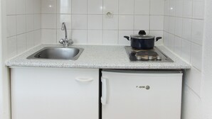 A compact kitchen with a sink, a stove, and a small refrigerator. - ABITEL - Les Studines d'Ornon (Villenave-d'Ornon)