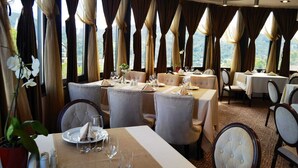 A restaurant with multiple tables, chairs, and a view of the outdoors. - Grand Hotel Belvedere Brasov (Brasov)