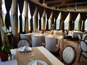 A restaurant with multiple tables, chairs, and a view of the outdoors. - Grand Hotel Belvedere Brasov (Brasov)