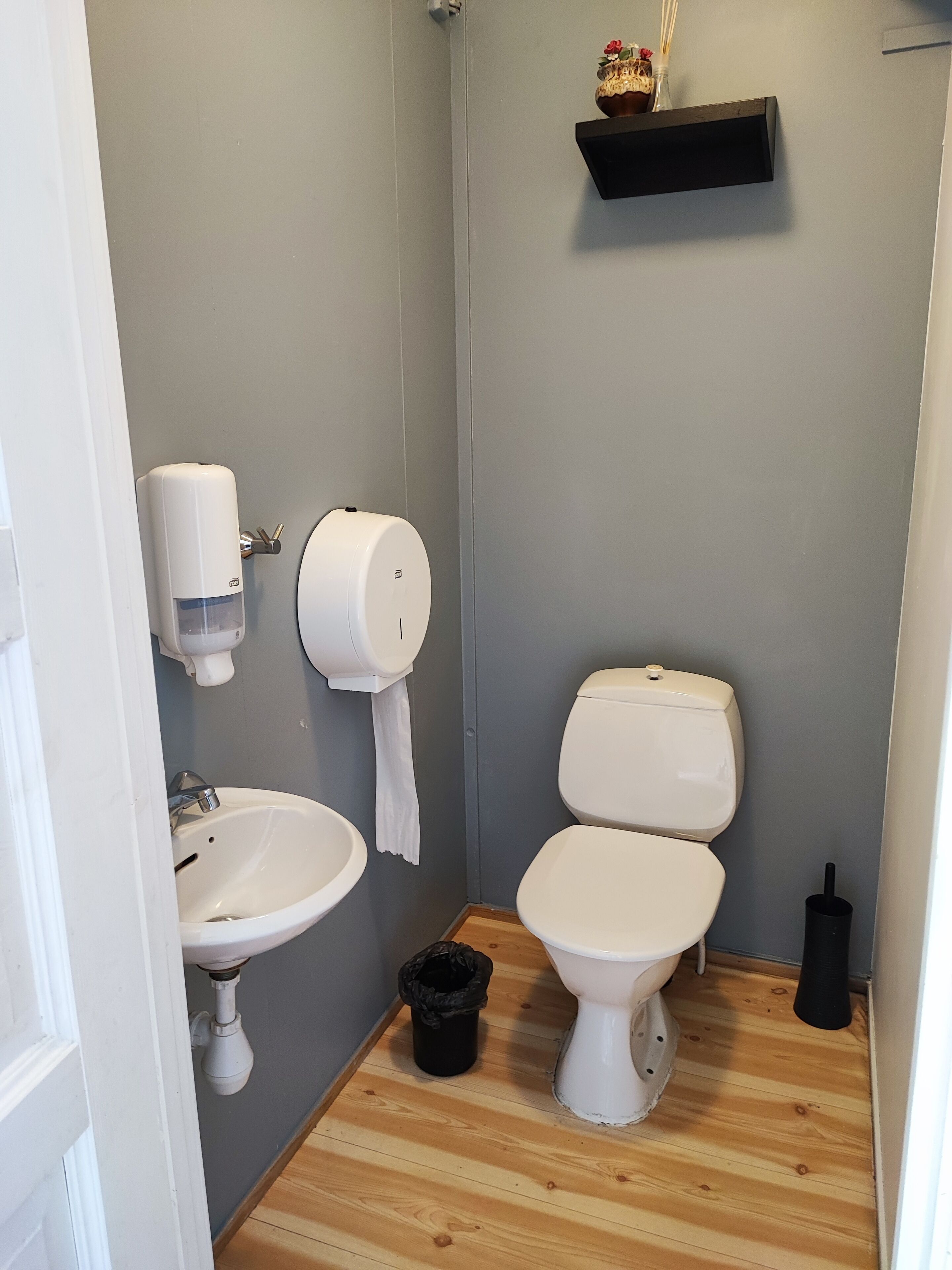 A bathroom with a sink, toilet, and hand dryer.