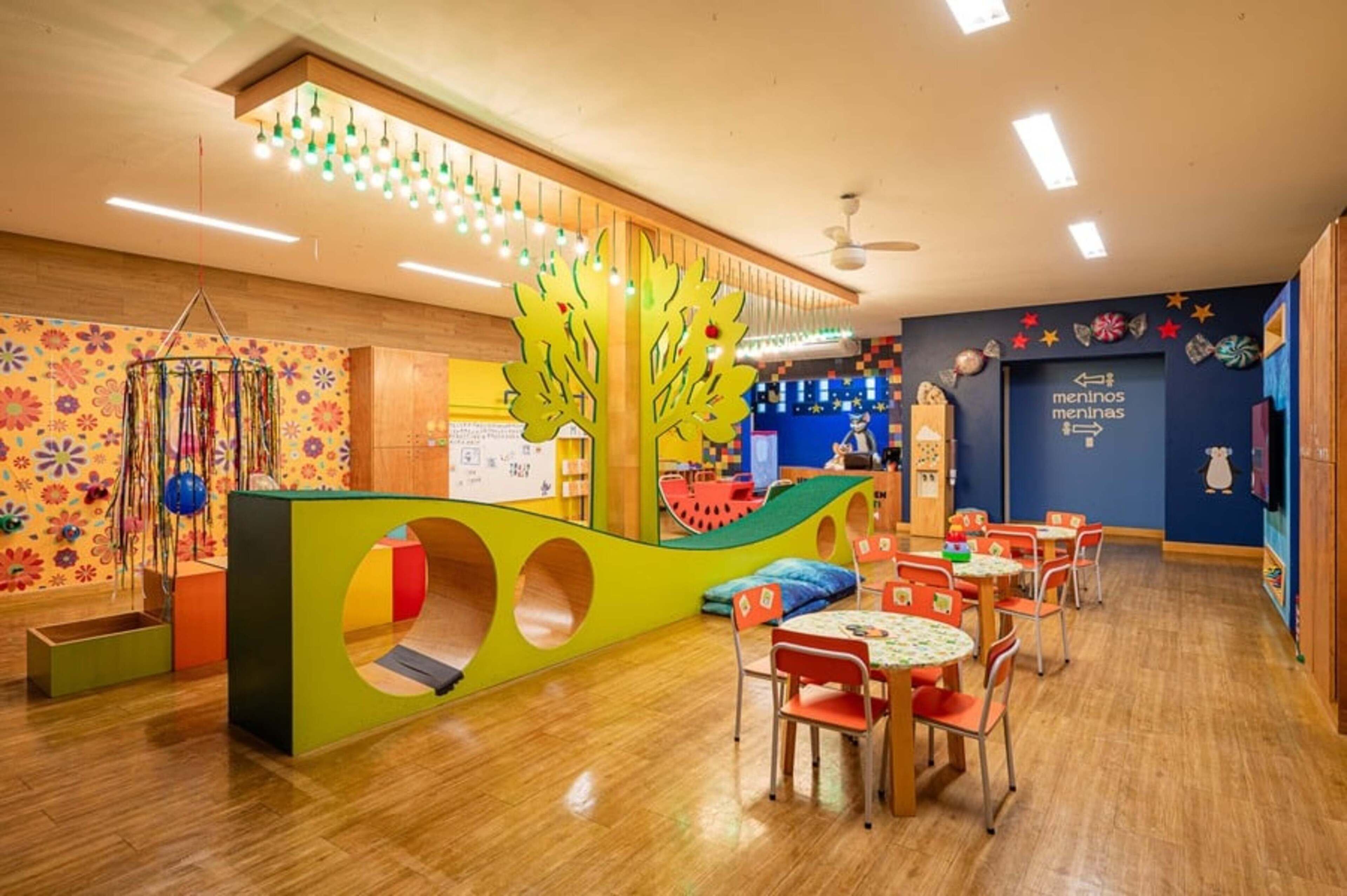 A children's play area with colorful play structures, tables, and chairs.