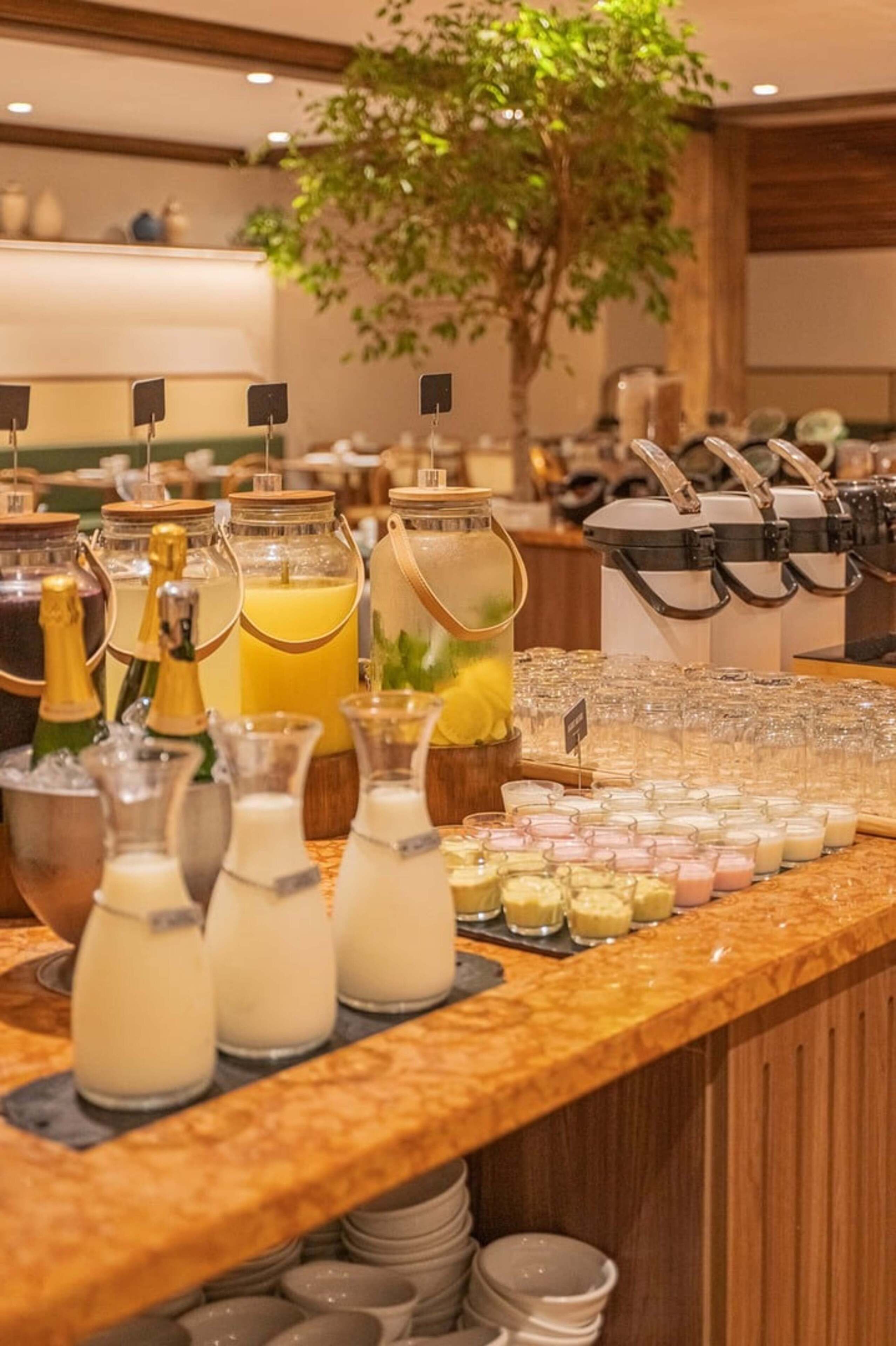 A buffet with various food and drink options, including milkshakes, juices, and desserts.