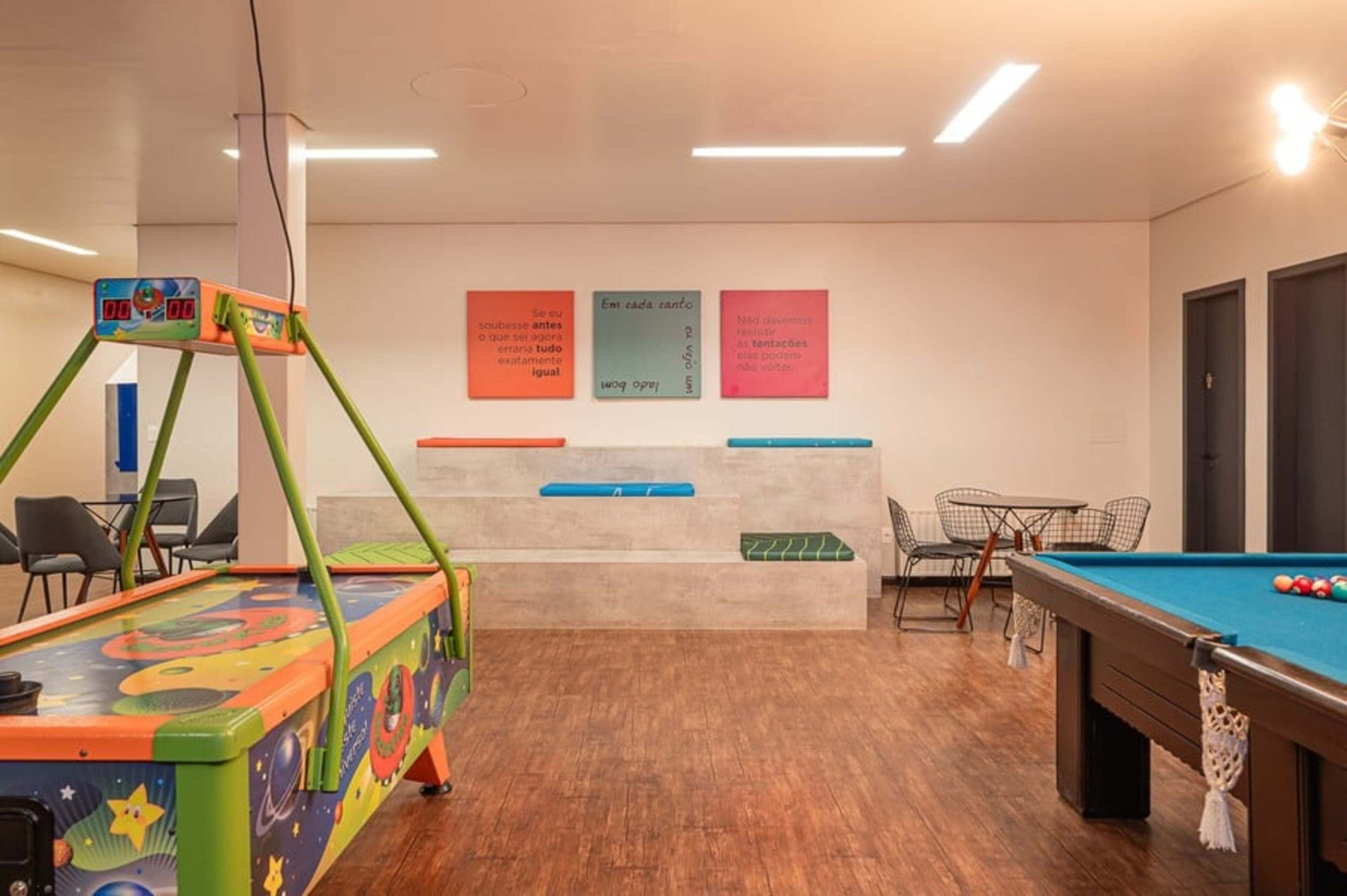 A billiards room with a pool table, chairs, and a colorful children's table.