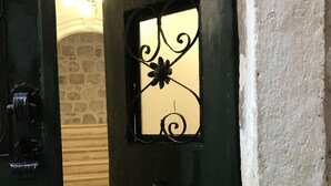 A dark green door with a decorative metal window featuring a floral design. - Rilati Old Town Palace (Dubrovnik)