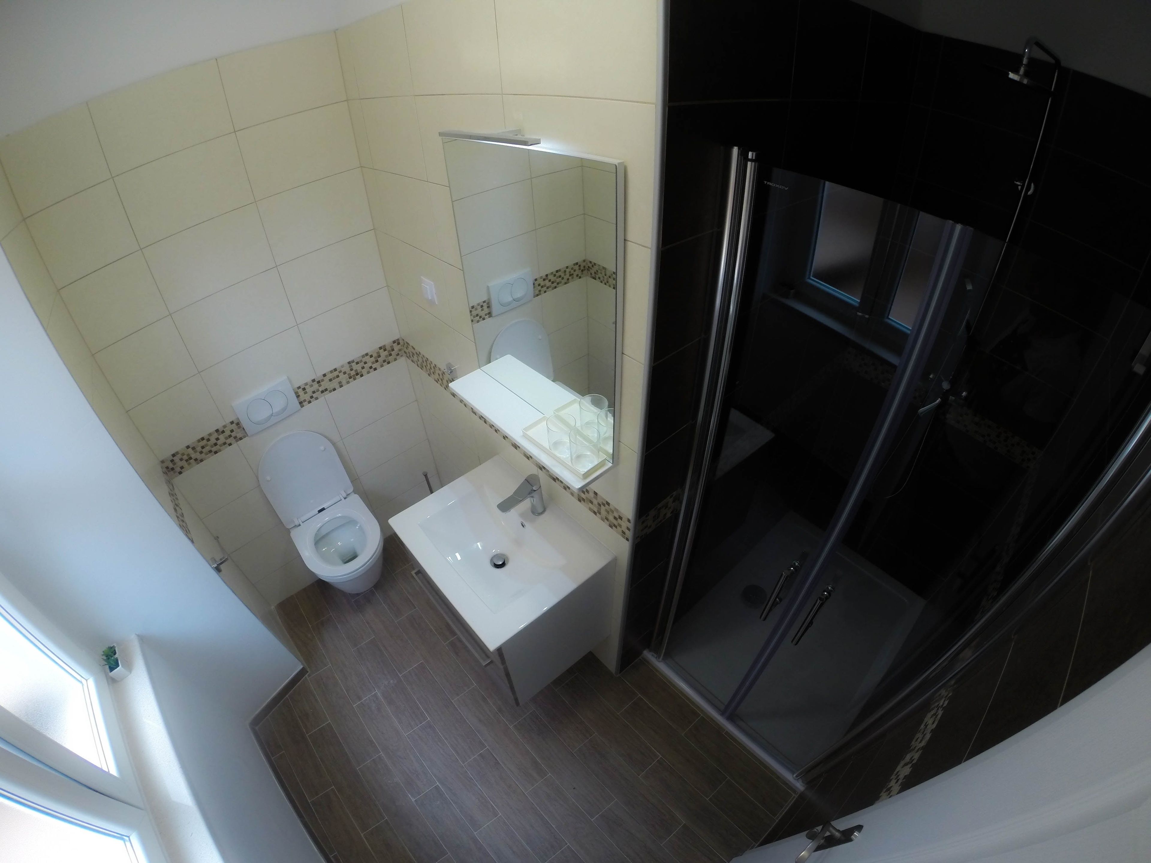 A bathroom with a toilet, sink, and shower area.