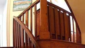 A wooden staircase with a handrail, leading to an upper floor.