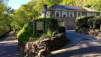 A stone building with a signboard indicating it is a country house offering bed and breakfast services.