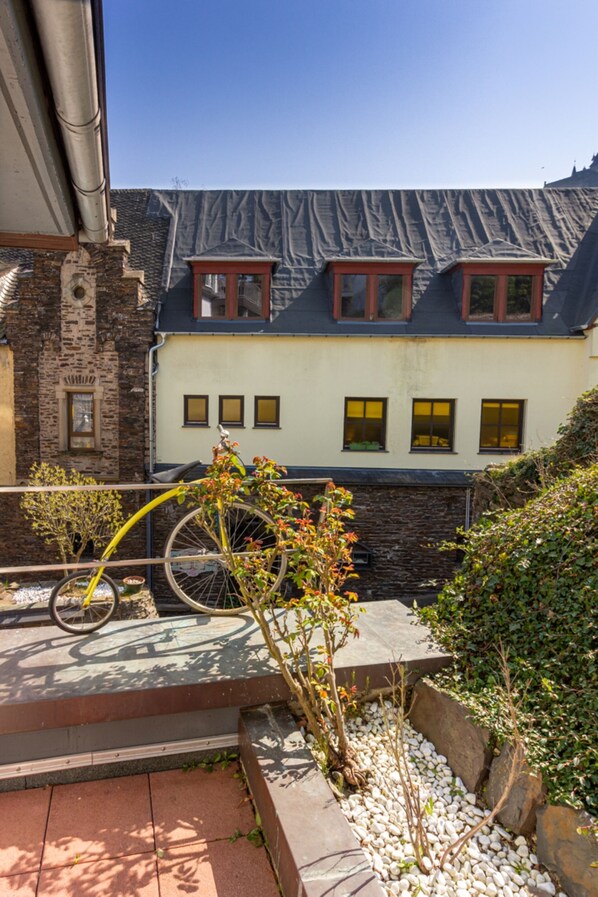 A building with a stone facade, a bicycle in the foreground, and a clear blue sky. - Villa Tummelchen (Cochem)