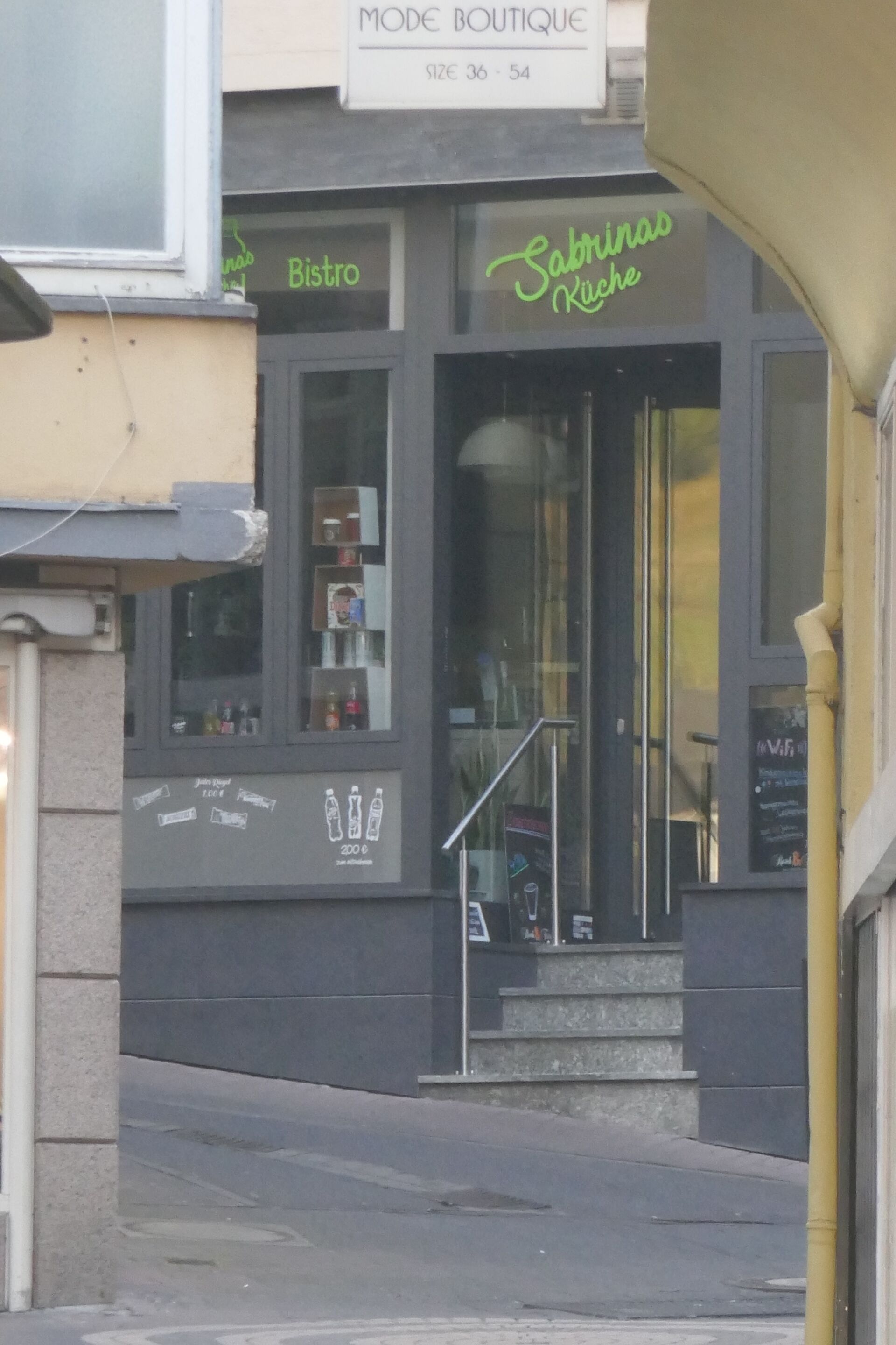 Un escaparate con un letrero que dice "Sabrina's Kitchen" y un letrero de "Bistro" encima.