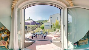 A room with a large sliding glass door leading to an outdoor patio area with a table and chairs. - Villa Tummelchen (Cochem)
