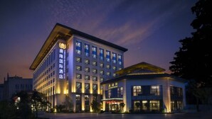 Un edificio moderno de hotel con varios pisos y una entrada destacada.