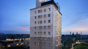 Moderni hotellirakennus, jossa on useita kerroksia ja sen yläosassa näkyvä, huomiota herättävä kyltti.
