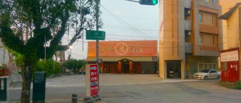 A street corner with a traffic light, a building with a sign reading "City Restaurant," and a tree.