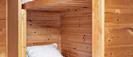 Una litera de madera con ropa de cama blanca.
