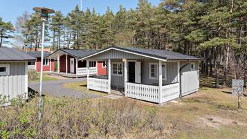 A row of cabins with white railings, surrounded by a forest.