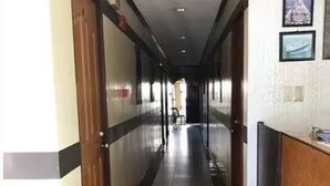 A long, narrow hallway with a reception desk on the right, tiled floors, and doors on both sides. - Herbies Mansion (Olongapo)