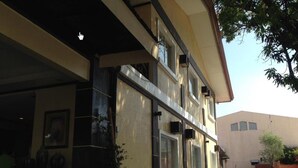 A two-story building with a flat roof, large windows, and a covered entrance area. - Herbies Mansion (Olongapo)