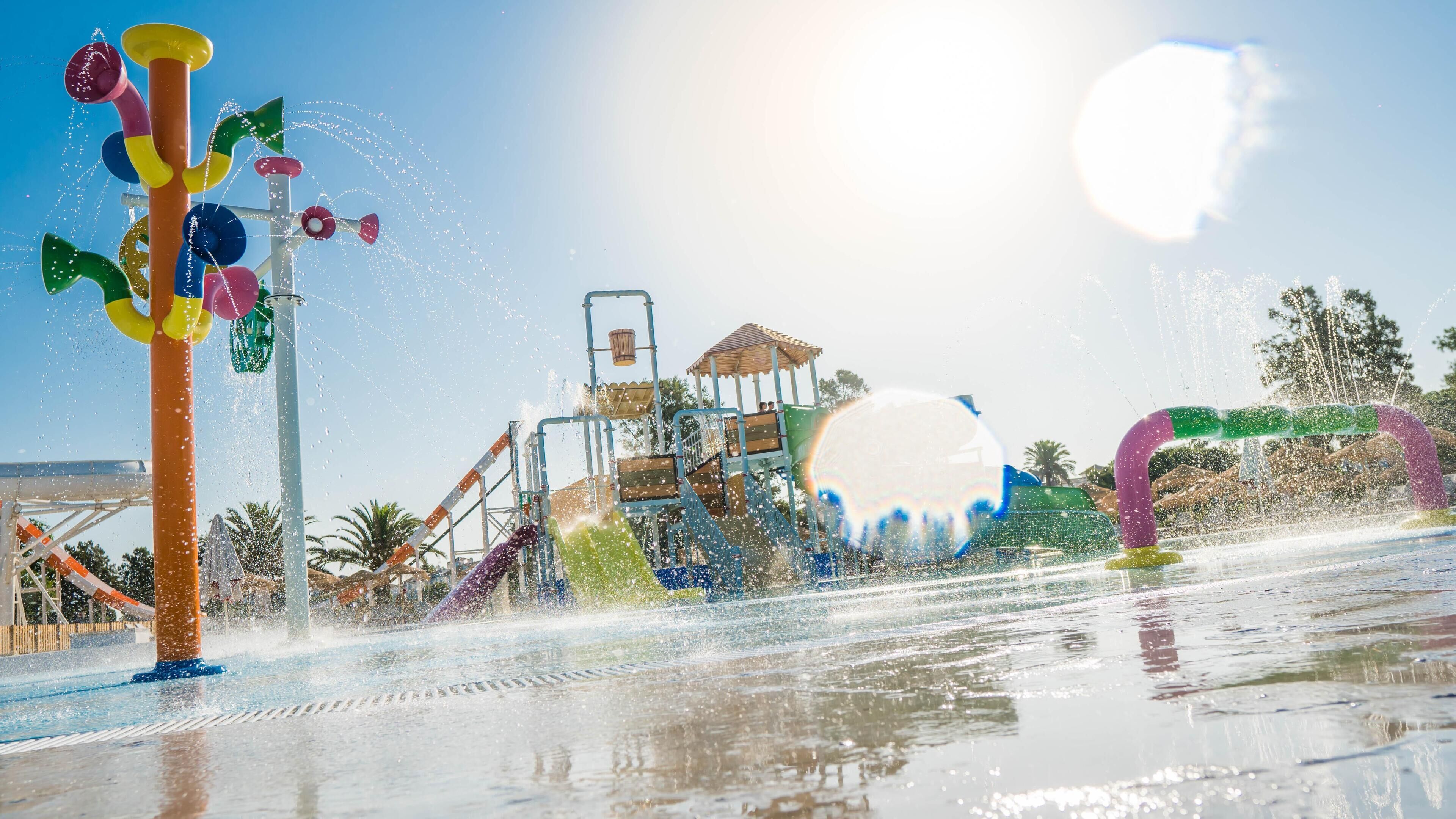 A water park with a large water slide and a play structure.