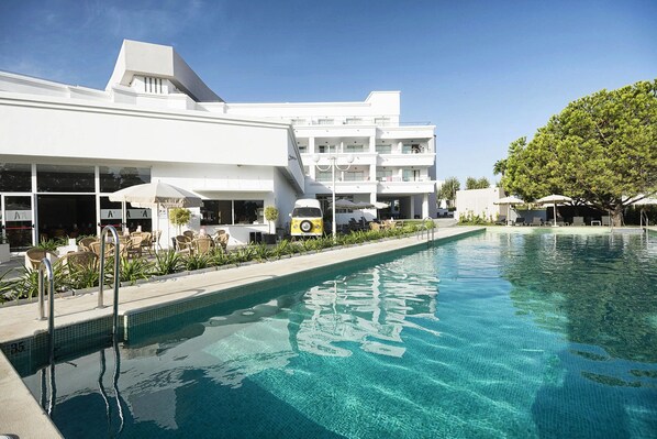 Alberca al aire libre, sombrillas en la alberca y camastros 