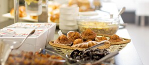 A buffet with various food items, including pastries and a bowl of salad. - ALEGRIA Costa Ballena (Rota)