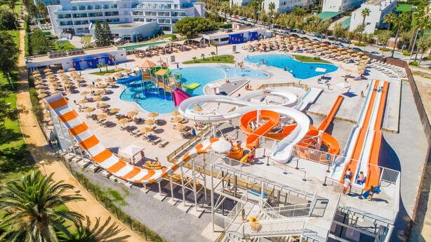 An aerial view of a resort with multiple swimming pools, water slides, and sun loungers. - ALEGRIA Costa Ballena (Rota)