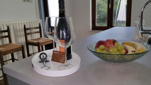 A kitchen counter with a wine bottle, a wine glass, and a bowl of fruit. - Mansion 6 (Maastricht)