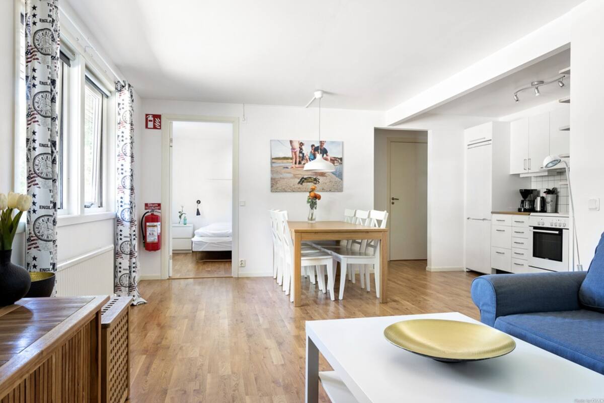 Uma sala moderna com área de jantar, cozinha e quarto.