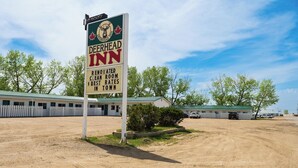 Un panneau indiquant un motel, orné d’un logo représentant un cerf, et portant le nom « Deerhead Inn ».