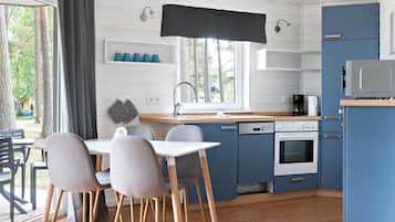 Una cocina compacta con comedor, que incluye un fregadero, estufa y alacenas.