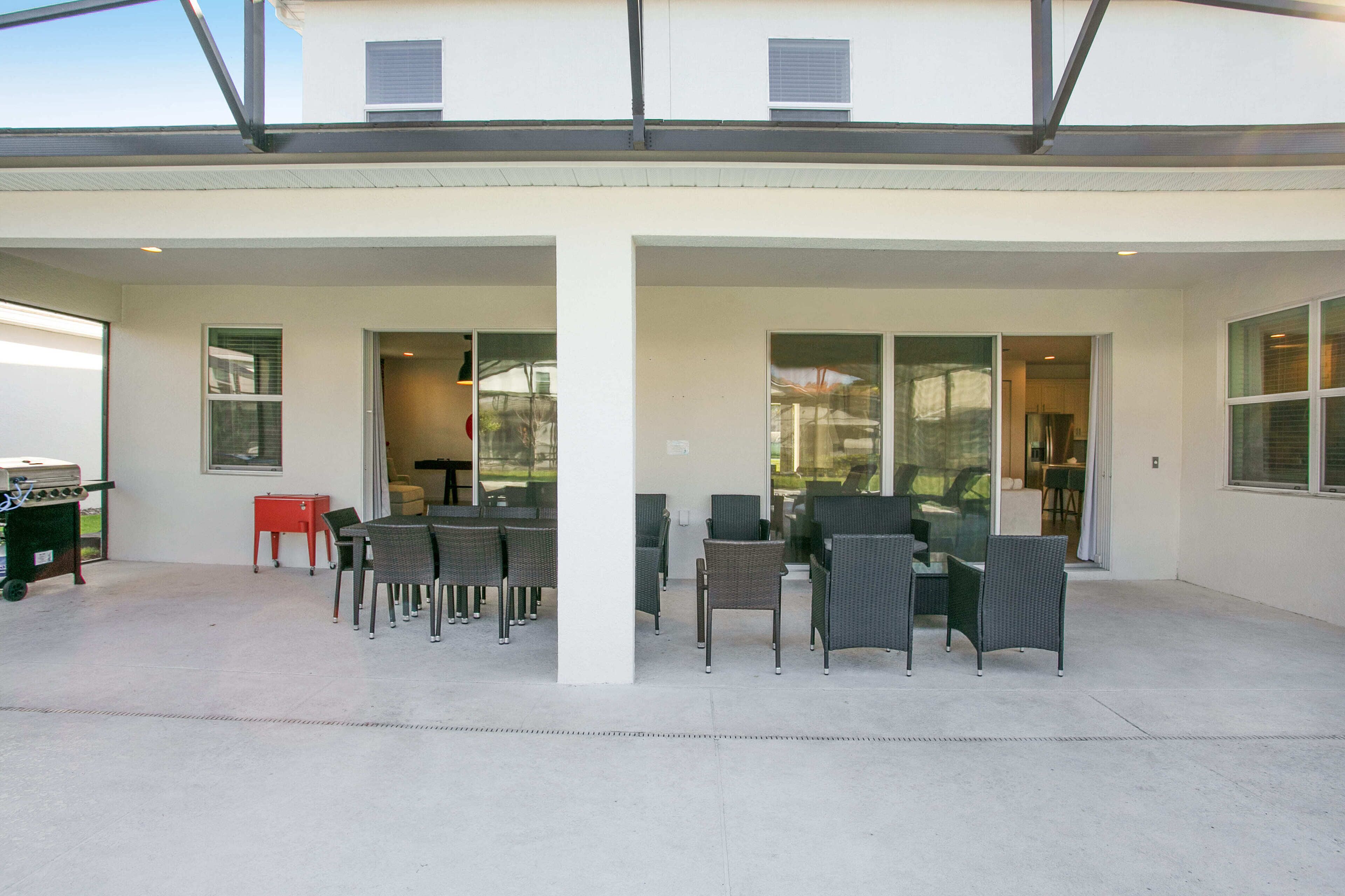 A covered patio with outdoor seating and a barbecue grill.