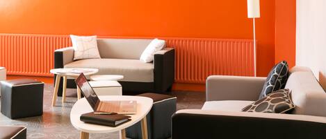 A modern lounge area with sofas, a coffee table, and a laptop.