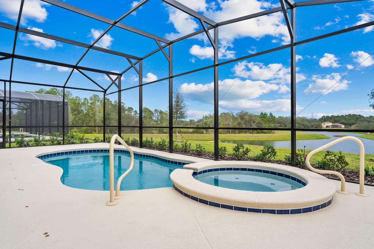 A pool area with two hot tubs and a clear view of the surrounding landscape.