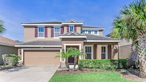 A two-story house with a garage, a front porch, and a well-maintained lawn. - Solterra Resort (Davenport)