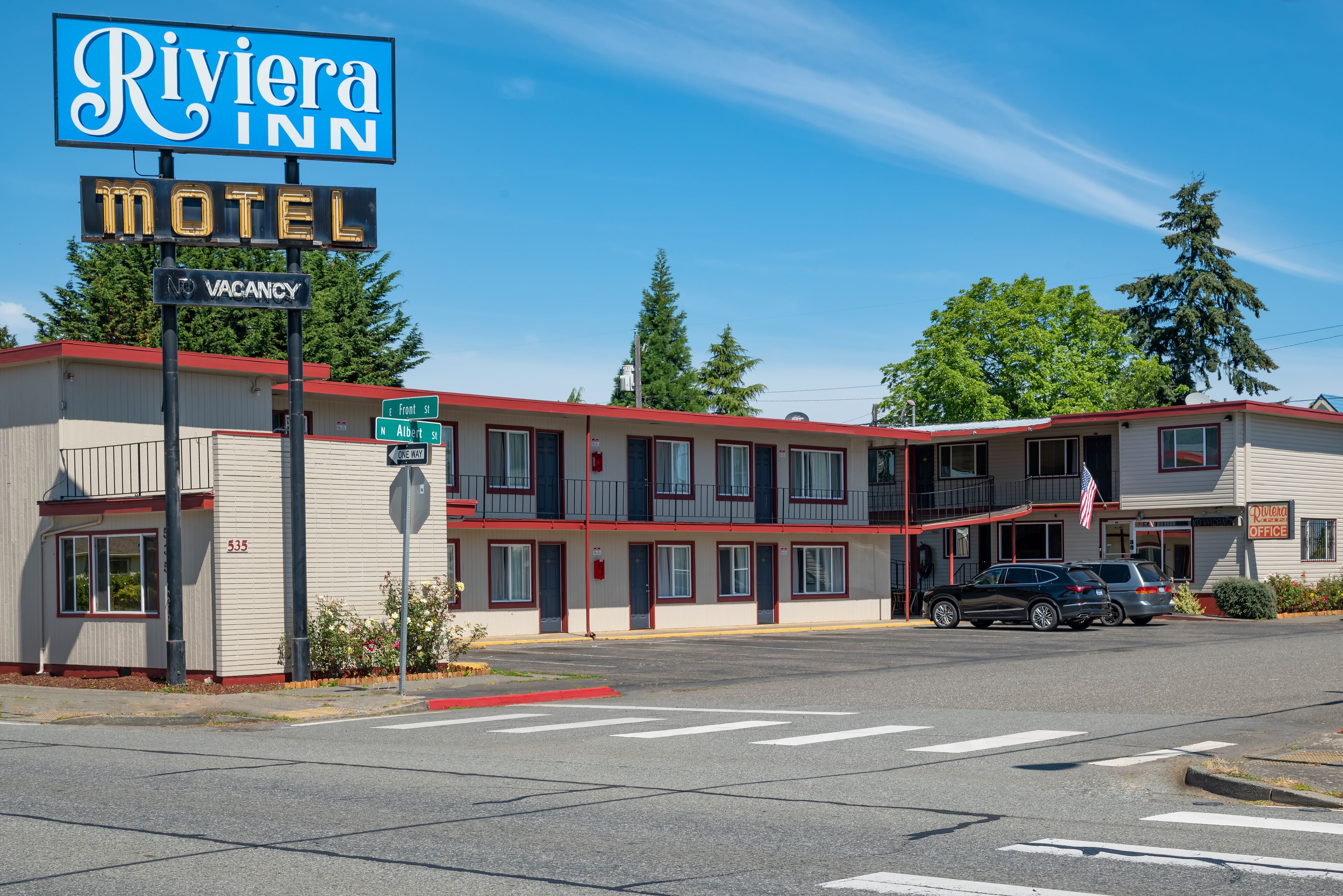 A motel with a sign reading "Riviera Inn Motel" and a "No Vacancy" sign.