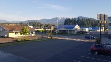 A motel with a blue roof, a stop sign, and a mountain in the background.