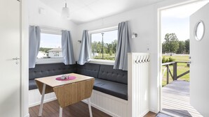 A room with a built-in bench seating area, a small table, and a view of the outdoors through a window. - First Camp Karlstad (Karlstad)