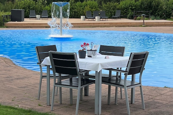 Una piscina al aire libre, sillones reclinables de piscina