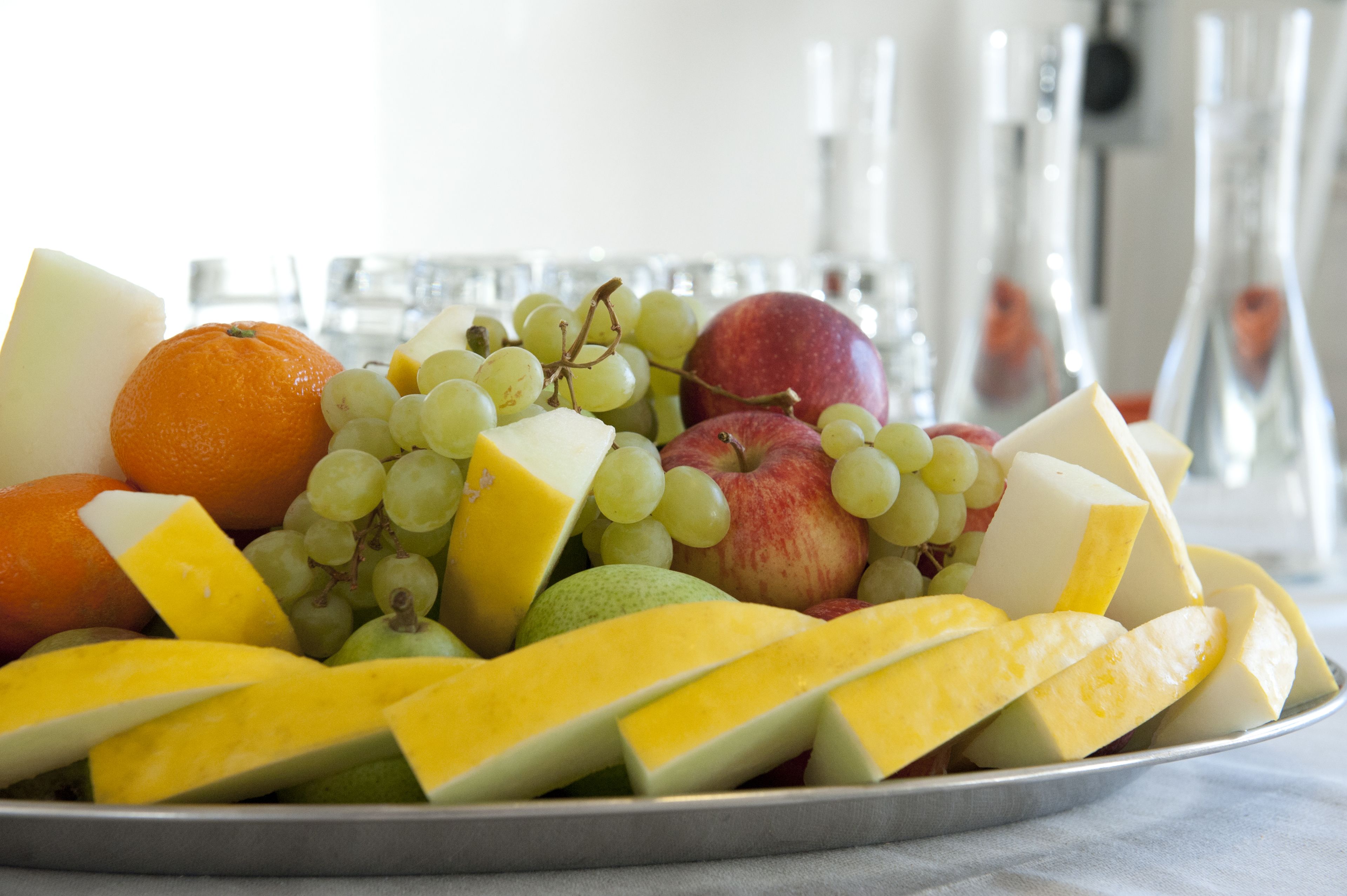 Eine Obstplatte mit Trauben, Äpfeln, Orangen und Käsescheiben.