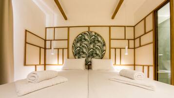 A hotel room with a large bed, two bedside tables, a wall-mounted artwork, and a window.