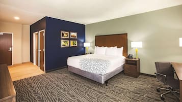 A hotel room with a bed, bedside tables, a desk, and a chair.