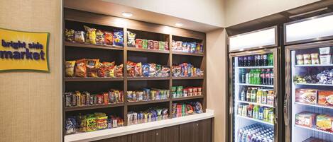 A snack and beverage vending area with multiple shelves of snacks and two refrigerated beverage dispensers.