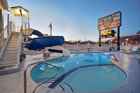 Una piscina al aire libre, sombrillas. Expedition Lodge Moab Arches National Park