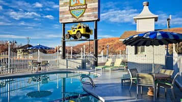 Een buitenzwembad, parasols voor strand/zwembad