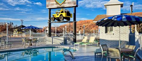 Een buitenzwembad, parasols voor strand/zwembad
