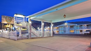 Une station-service bien éclairée, dotée d’une zone abritée, d’un parking clôturé et d’un bâtiment sur lequel est apposée une enseigne indiquant « Expedition Lodge ».