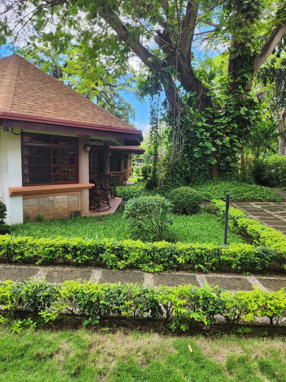 A traditional house with a tiled roof, surrounded by lush greenery and a well-maintained garden.