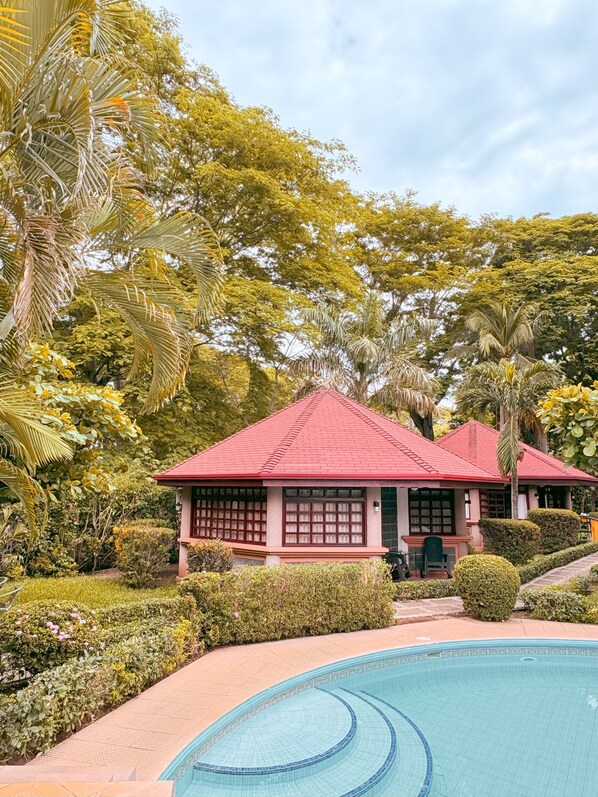 A building with a red roof and a pool area. - Hotel Villa Acacia (Sardinal)