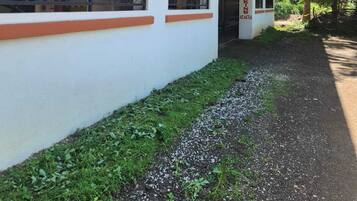 Un edificio con fachada blanca, varios balcones y un camino de grava que lleva a la entrada.