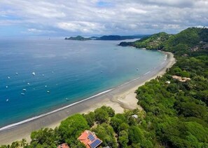 A coastal landscape with a beach, boats, and a hilly terrain. - Hotel Villa Acacia (Sardinal)